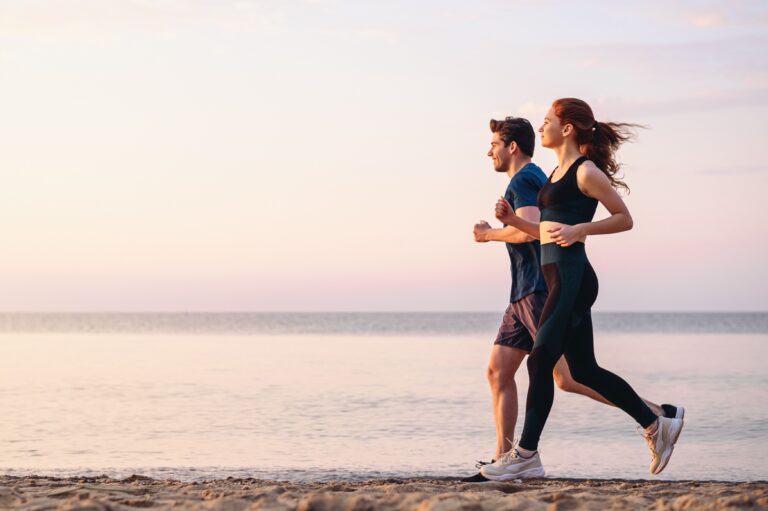 couple jogging along sandy beachfront