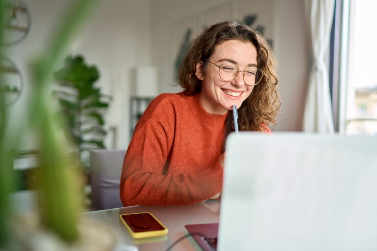 woman smiling while using laptop